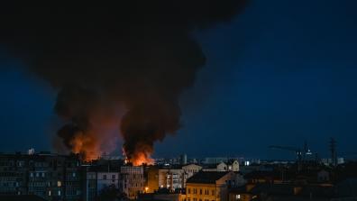 A dramatic scene of a fire with smoke rising over the cityscape of Kyiv at night. Photo by Алесь Усцінаў from Pexels