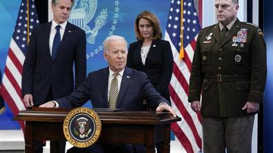 President Joe Biden pauses after signing a delegation of authority in the South Court Auditorium on the White House campus in Washington. From left, Antony Blinken, Biden, Kathleen Hicks and General Mark Milley