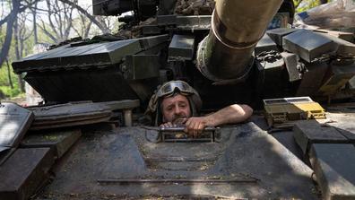 A Ukrainian soldier climbs into a tank to repair it in Ukraine's eastern Donetsk region on April 27. (Evgeniy Maloletka/AP)