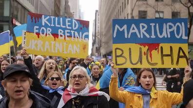 People attend a 'Stop Genocide of Ukraine People' rally and protest against Russia's invasion of Ukraine, in Times Square in New York City. / Jeenah Moon/Reuters