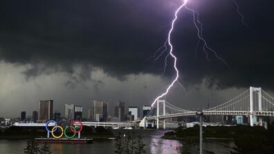 Lightning over the Rainbow Bridge in Tokyo with the Olympic rings alongside it