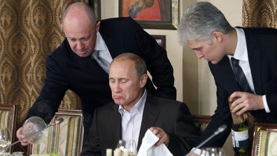Yevgeniy Prigozhin, left, serves Russian President Vladimir Putin at Prigozhin's restaurant outside Moscow. On Wednesday, Facebook linked Prigozhin to efforts to spread disinformation in Africa.