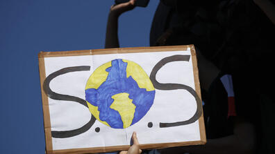 A protester shows a placard during a climate demonstration Friday, Sept. 20, 2019 in Paris. In Canberra and Kabul, Cape Town and Berlin, and across the globe, hundreds of thousands of people took the streets Friday to demand that leaders tackle climate ch