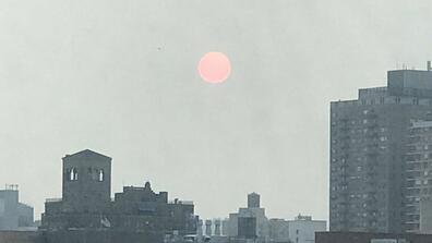 Orange sun view in New York City due to distant fires