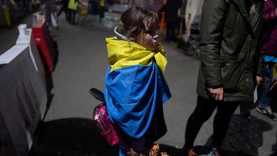 Anastasia, 8, wraps herself in a Ukrainian flag at the border crossing in Medyka, Poland, on March 23.