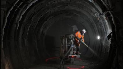A worker sprays a layer of cement protection in a tunnel for radioactive waste in an underground laboratory run by Andra, an agency that manages the waste, in Bure, eastern France, Thursday, Oct. 28, 2021.