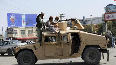 Taliban fighters stand guard outside Hamid Karzai International Airport in Kabul, Afghanistan