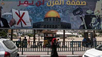 A picture taken on June 16, 2019, shows a poster in Gaza City denouncing the US Middle East plan with Arabic writing on the poster saying ‘The deal of the century will not pass.’ 
