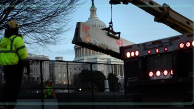 Workers reinforce a crowd-control fence around Capitol Hill with concrete barriers