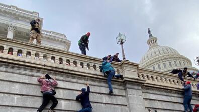 people climb the capitol wall