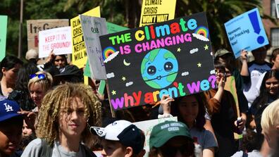 "the climate is changing, why aren't we?" sign