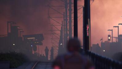 a person walks down a dark smoky path