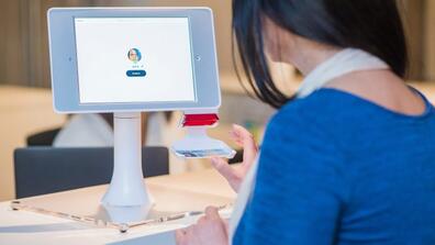 A person looks at a tablet screen that has recorded their face.