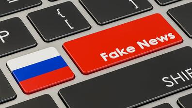 a keyboard where one key says "fake news" and the other has a Russian flag on it