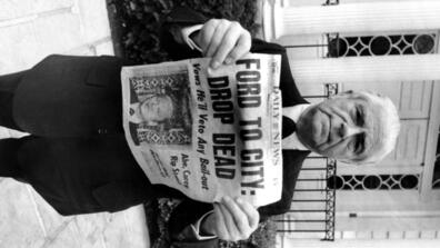 a man holds an old newspaper