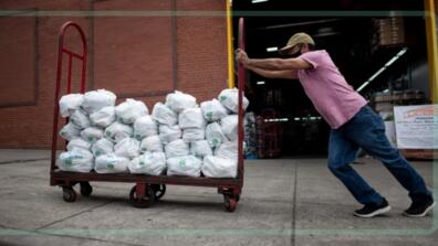 Felix Pinzon, an unemployed construction worker, pushes a cart of food donations in May in the Bronx