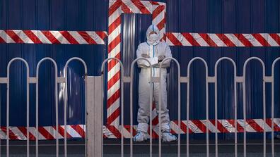 man in hazmat suit in front of red tape