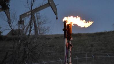 A flare burns methane produced by an oil well near Watford City, N.D.