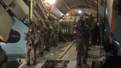 Russian service members disembark from a military aircraft, as part of a peacekeeping mission amid mass protests in Almaty and other Kazakh cities, at an airfield in Kazakhstan, in this still image from video released by Russia's Defense Ministry