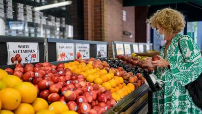 woman shopping in grocery store with inflation 