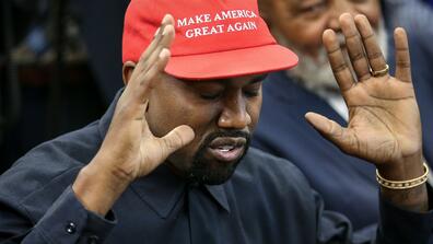 Kanye West wearing a MAGA hat