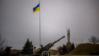 Image from Kiev with a Ukrainian Flag on the background, and a machine gun with wheels
