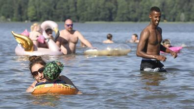 People play and swim in a lake