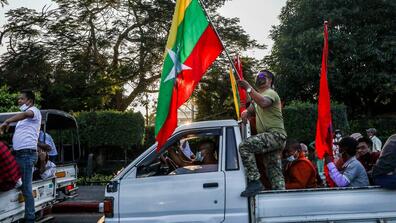 Supporters of the military in Myanmar wave flags 