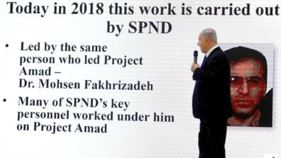 Israeli Prime Minister Benjamin Netanyahu stands by a screen with an image of Iranian nuclear scientist Mohsen Fakhrizadeh during a news conference at the Ministry of Defence in Tel Aviv, Israel, 