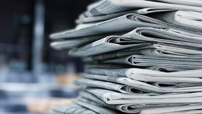 a stack of print newspapers