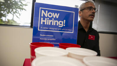 A sign that reads Now Hiring