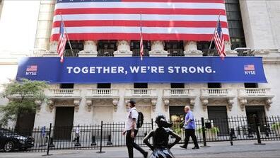 A banner hung over the New York Stock Exchange reads "together, we're strong"