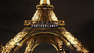 Image of the Eiffel Tower with a text on it that says "For the Planet"