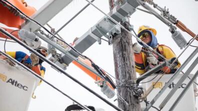 An electricity worker fixes a power line