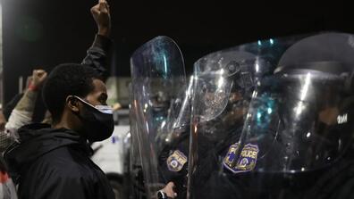 a protester stands in front of the police