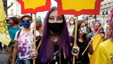 Climate activists hold placards as they march from the offices of Royal Dutch Shell towards Parliament Square in London