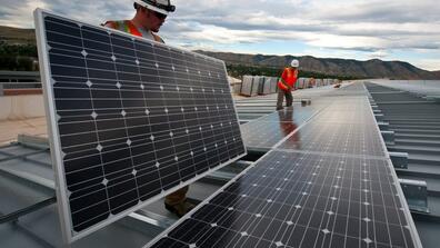 Workers install solar panels