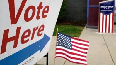 a voting location with a sign and american flags