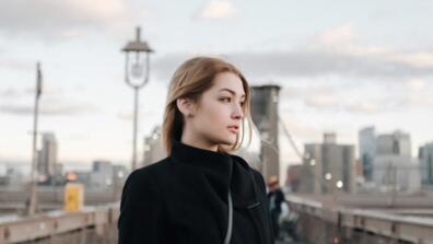 a woman stands on a bridge