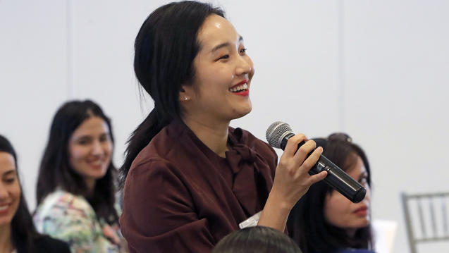 A person standing up with a mic in her hands