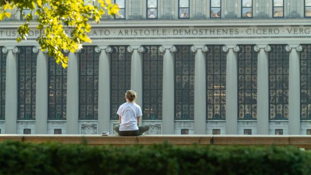 a student sitting in front of the library at Columbia University