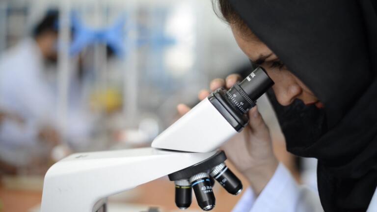 Woman looking into a microscope