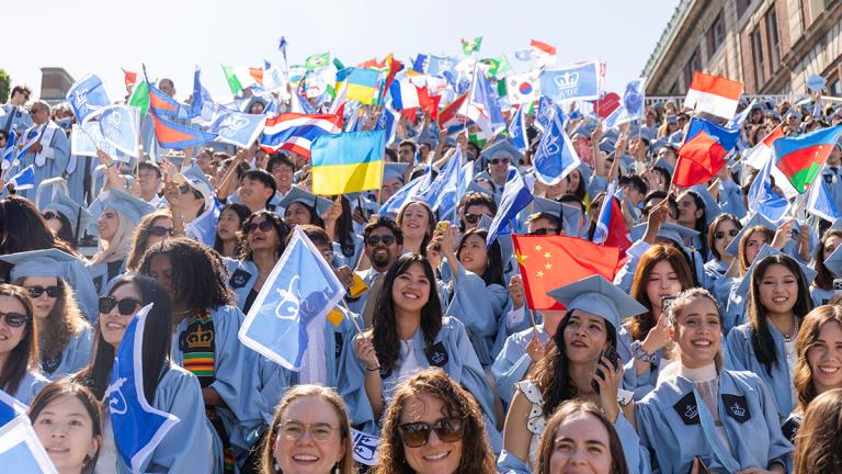 SIPA students waving international flags during the Columbia University commencement celebration