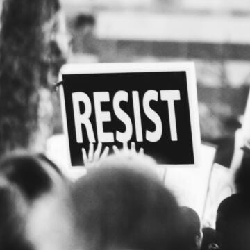 person holding resist poster