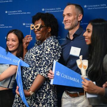 Four alumni taking a picture at a photobooth