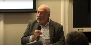 Joseph Stiglitz speaks at a 2023 conference on industrial policy -- here he is holding a hand microphone..