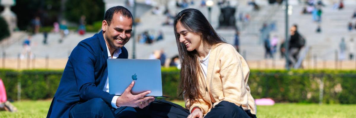 SIPA students on lawn with laptop