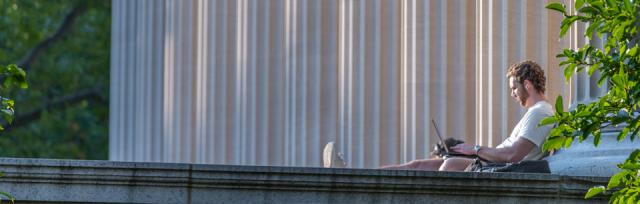 Student on sitting with laptop on Columbia SIPA campus