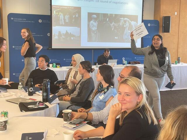 In the first phase of the negotiation simulation, student participants holding Track I talks worked against the backdrop of a protest.